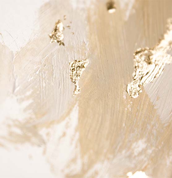 Close-up of textured beige and gold abstract paint on canvas.